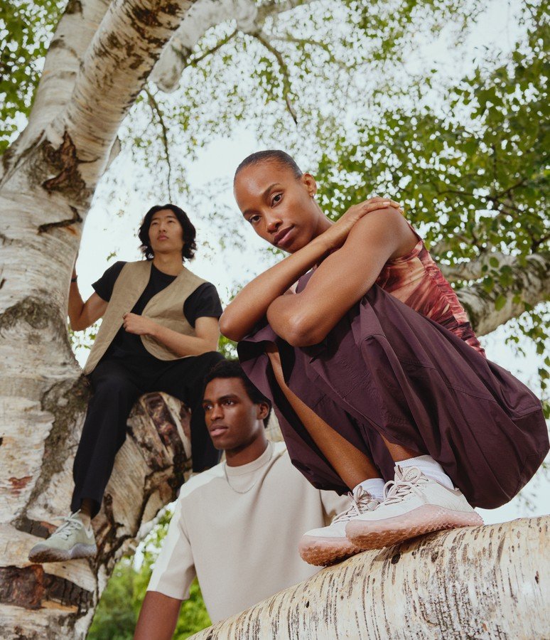 Group of friends resting on a birch tree wearing Merrell barefoot shoes
